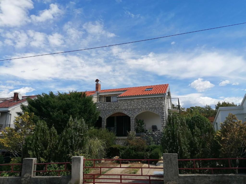 a stone house with a red roof at Apartment Njivice 5320b in Njivice