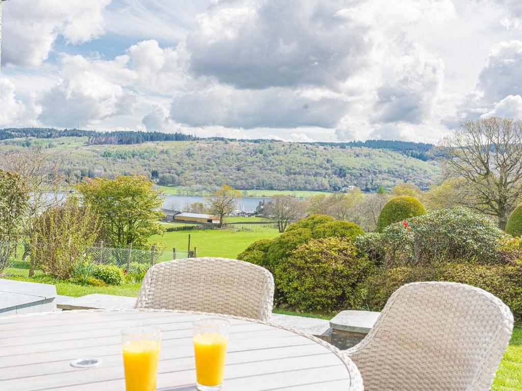 Una mesa con dos vasos de jugo de naranja encima. en Cedar Wood Coniston, en Coniston