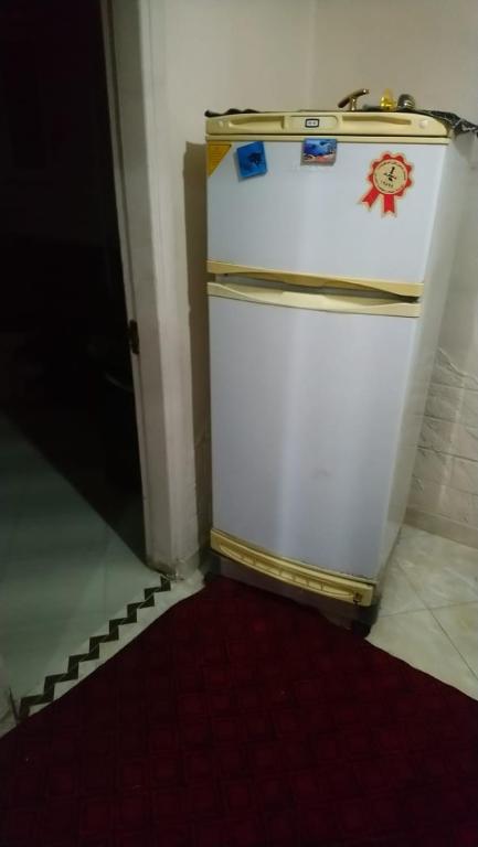 una nevera blanca en una habitación con suelo rojo en الهرم en El Cairo