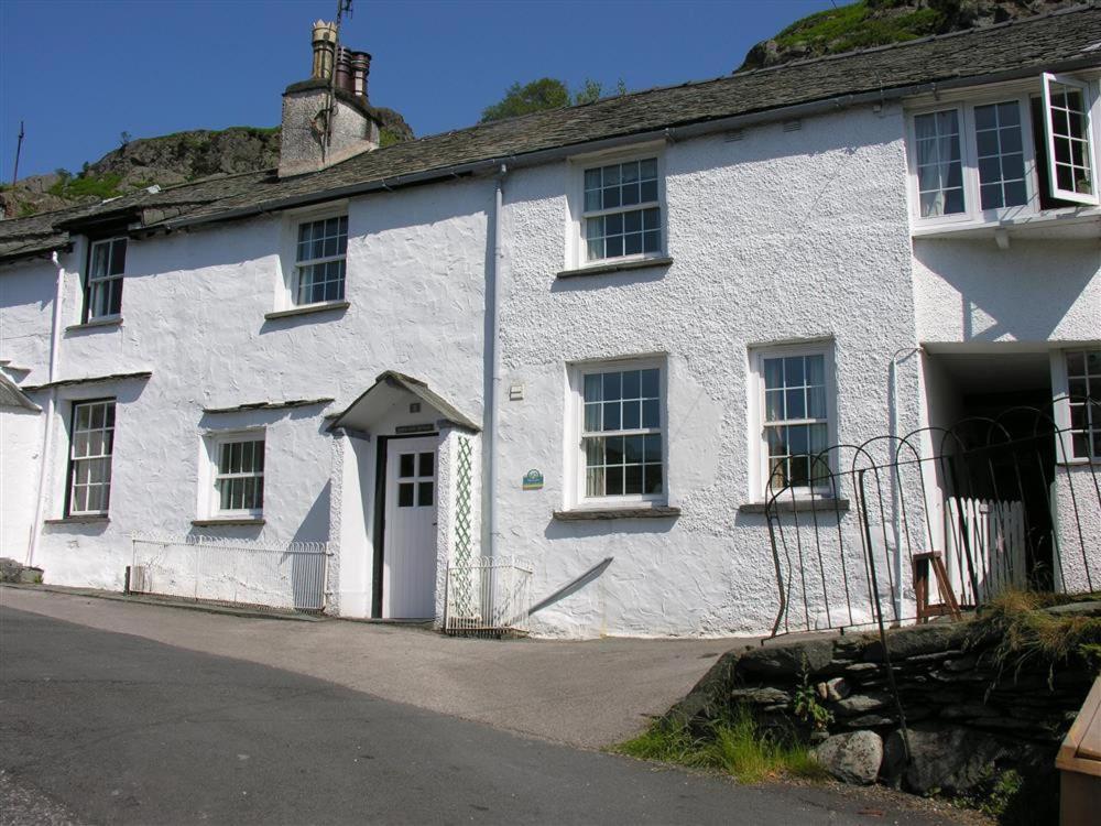 ein weißes Gebäude mit einer weißen Tür und Fenstern in der Unterkunft White Lion Cottage in Chapel Stile