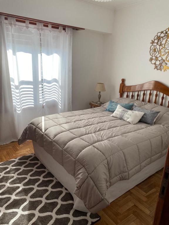 a bedroom with a large bed and a window at Alberdi Centro in Tandil