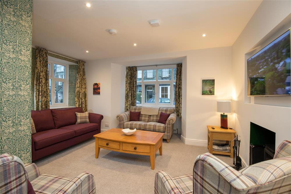 a living room with couches and a tv at Heatherley in Ambleside