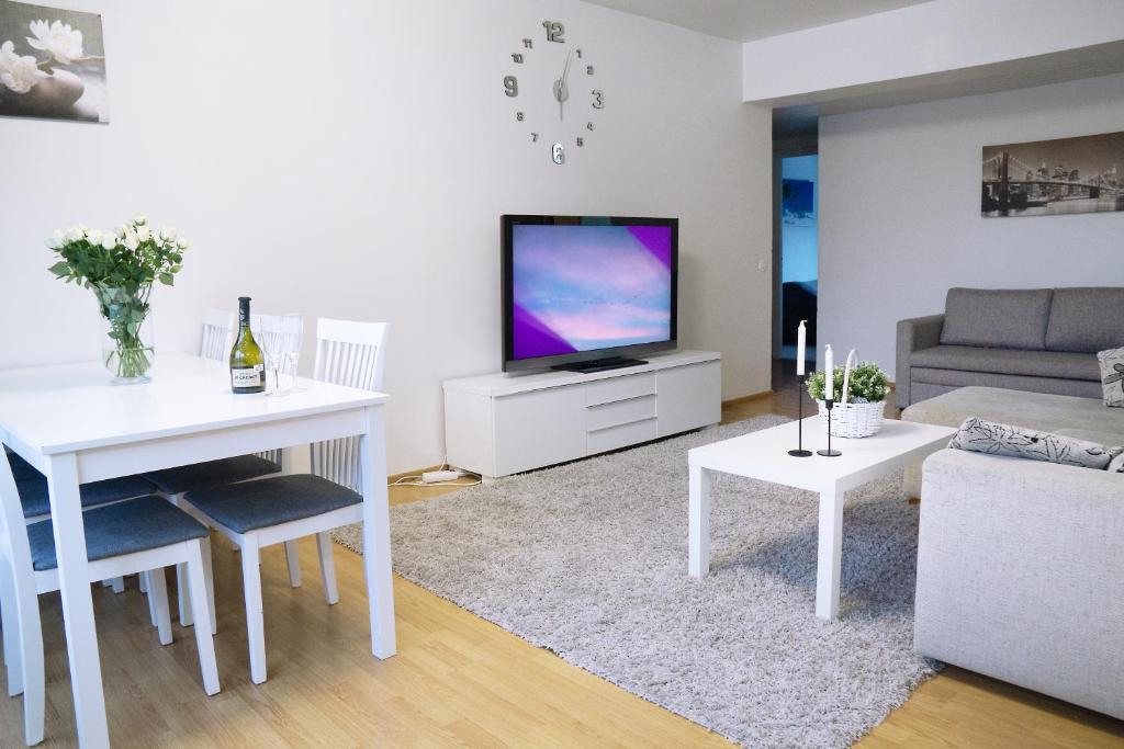 a living room with a white table and a television at 4-room apartment. Oulu city center in Oulu