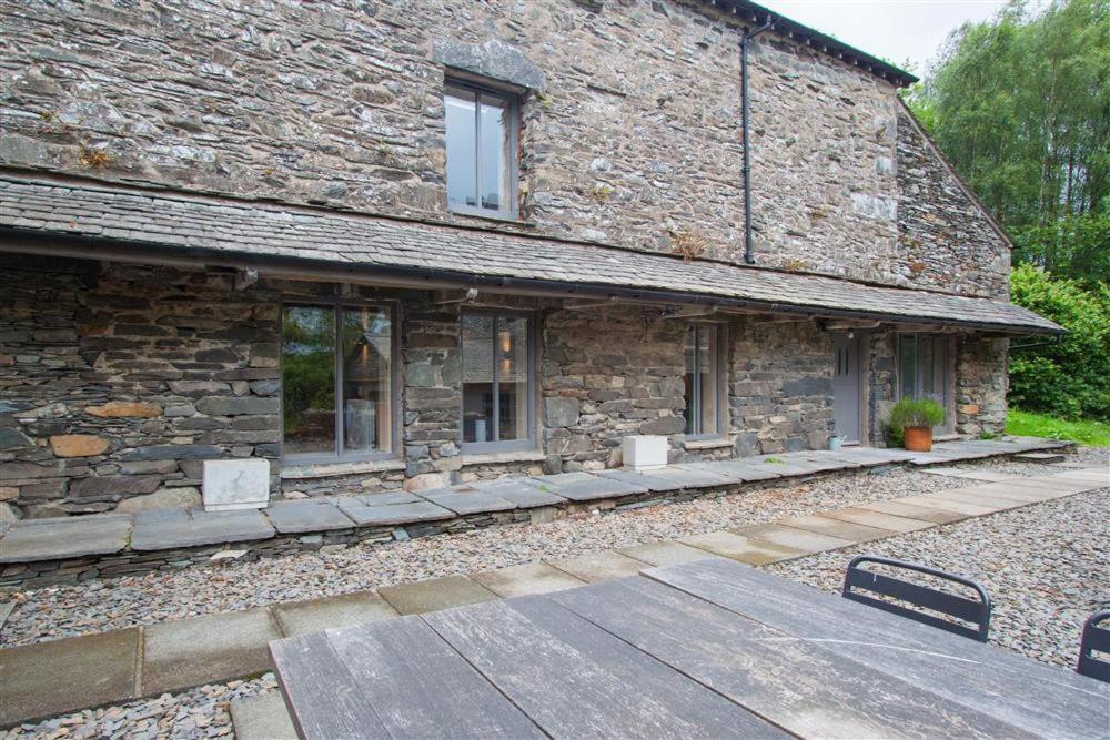 un edificio de piedra con una pasarela de madera delante de él en The Old Dairy en Ambleside