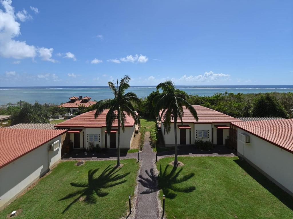 an aerial view of a house with palm trees and the ocean at Hotel La Teada Iriomote in Iriomote