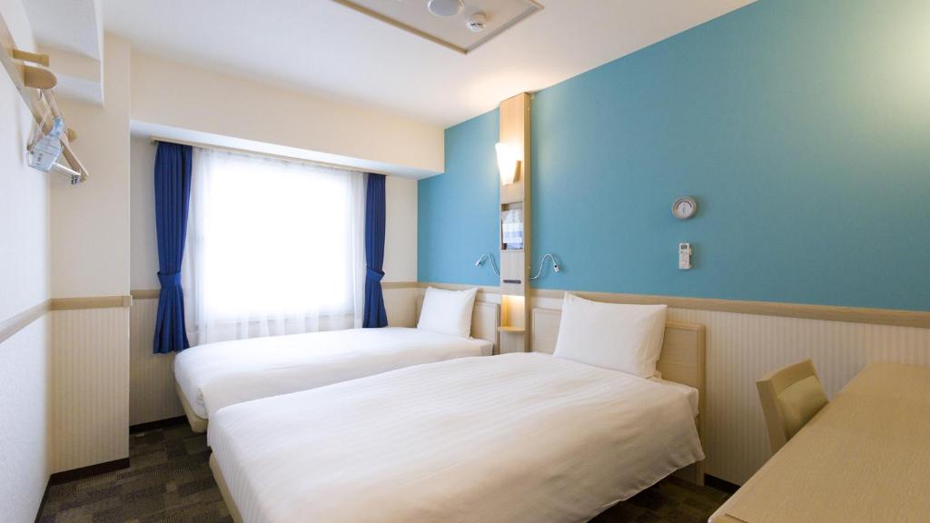 Habitación de hotel con 2 camas y ventana en Toyoko Inn Toride-eki Higashi-guchi, en Toride