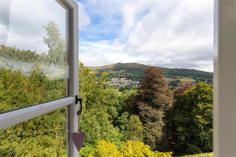 uma janela com vista para as árvores e para a cidade em Windermere Suite em Ambleside