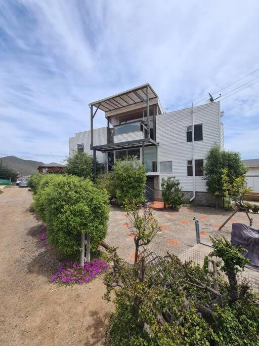 科金博的住宿－Gran casa en Totoralillo con vista al mar y más!，前面有灌木和鲜花的建筑