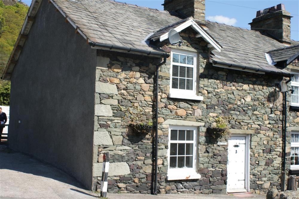 an old stone building with a large garage at Millcroft Cottage in Penrith