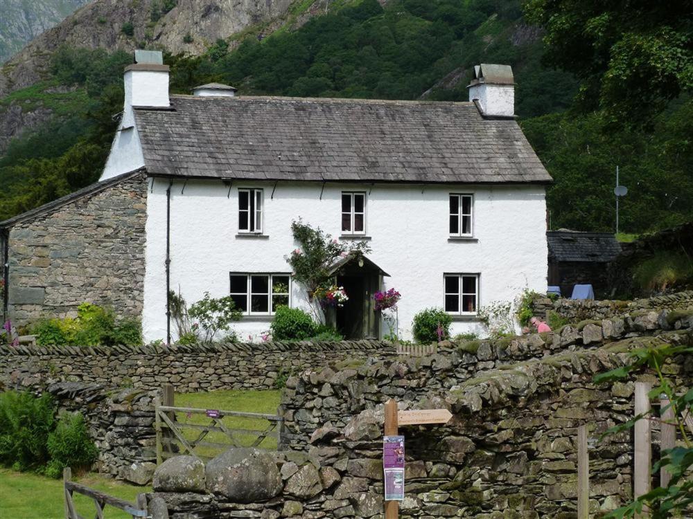 a white house on top of a stone wall at Yew Tree Farm in Coniston