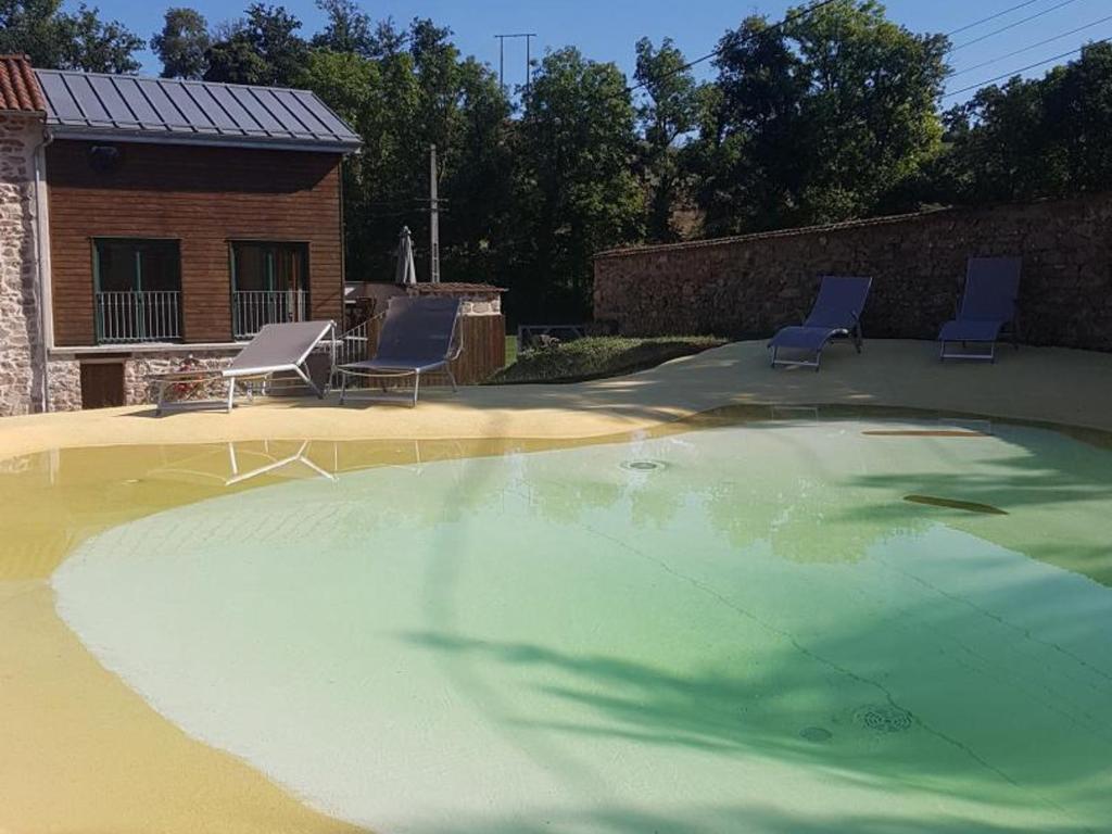 a large swimming pool with two chairs and a house at Gîte Croizet-sur-Gand, 6 pièces, 13 personnes - FR-1-496-25 in Croizet-sur-Gand