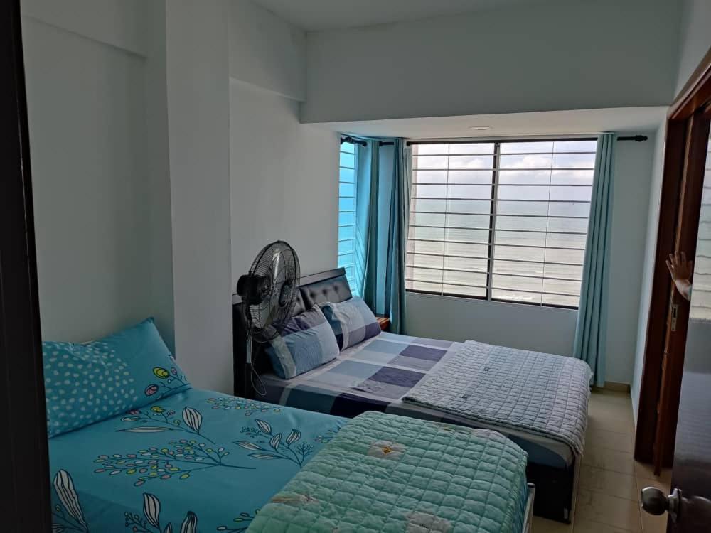 - une chambre avec 2 lits et une fenêtre dans l'établissement PD Paradise Lagoon Apartment North B-2-6, à Port Dickson