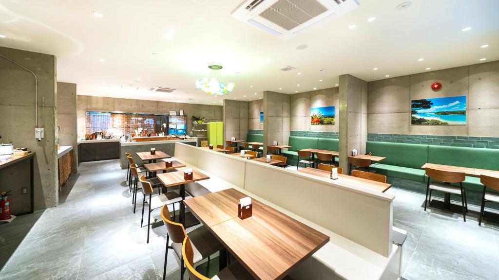 un restaurante con mesas y sillas de madera en The BREAKFAST HOTEL PORTO Ishigakijima en Isla Ishigaki