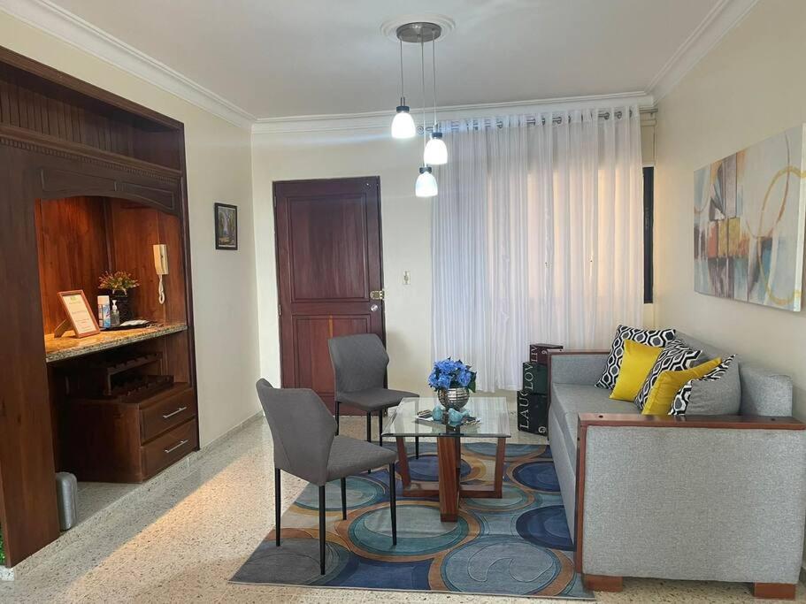 a living room with a couch and a table and chairs at MView: Comfortable, great location, city view in Santiago de los Caballeros