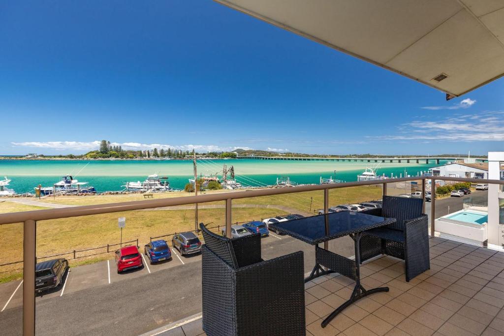 a balcony with a table and chairs and a view of the water at Shoreline 7 with 180 degree water views in Tuncurry