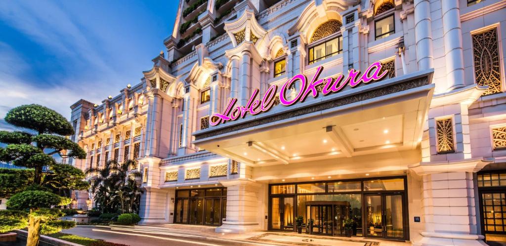 un edificio con una señal de neón en el costado. en Hotel Okura Macau, en Macau