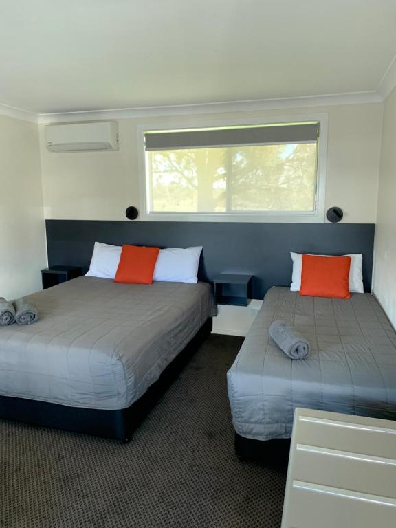 a room with two beds and a window at Altona Motel in Uralla