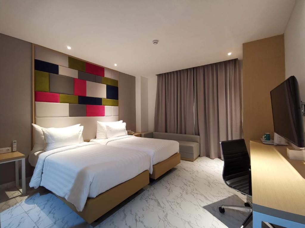 Postel nebo postele na pokoji v ubytování PALM PARK Hotel Surabaya