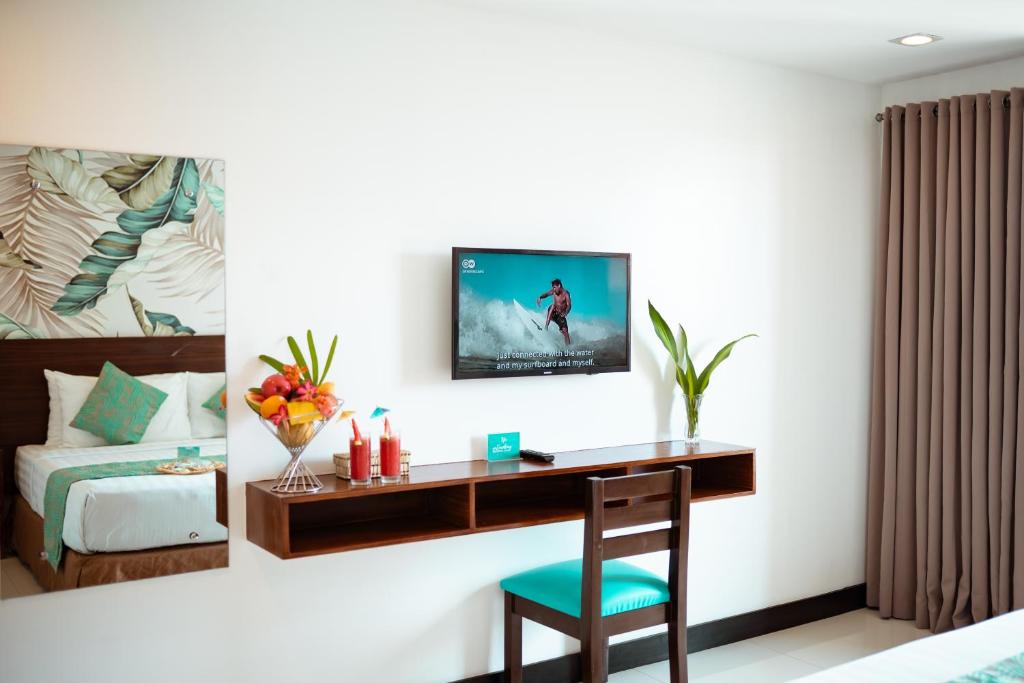 a bedroom with a desk and a bed with a tv on the wall at Jony's Boutique Hotel in Boracay