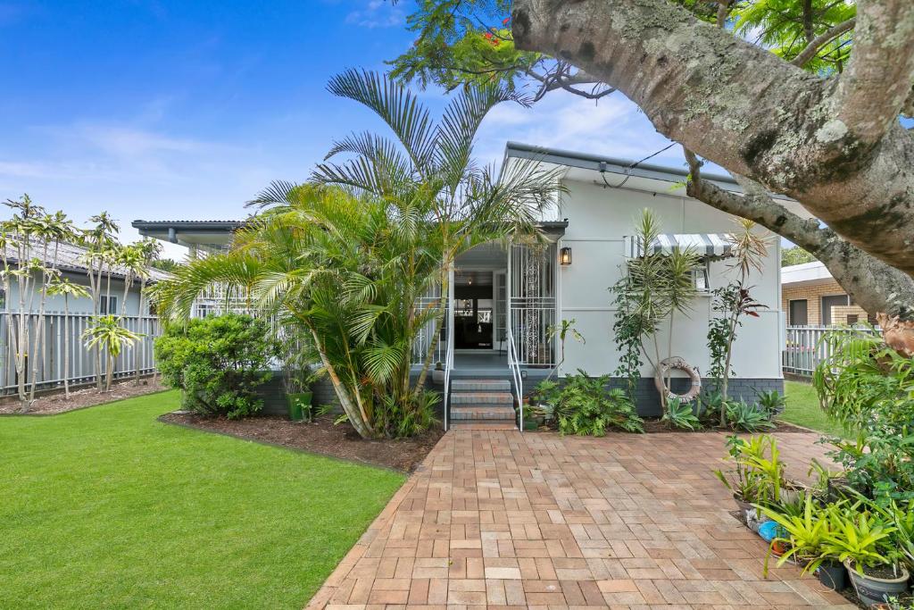 a house with a brick walkway in front of a yard at The Shack in Woorim