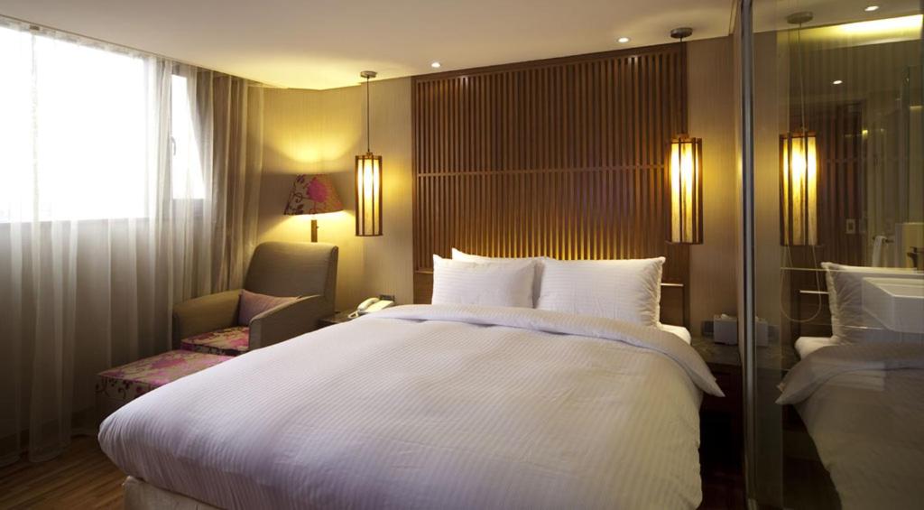 台北的住宿－承攜行旅-台北八德館，卧室设有一张白色大床和一扇窗户。