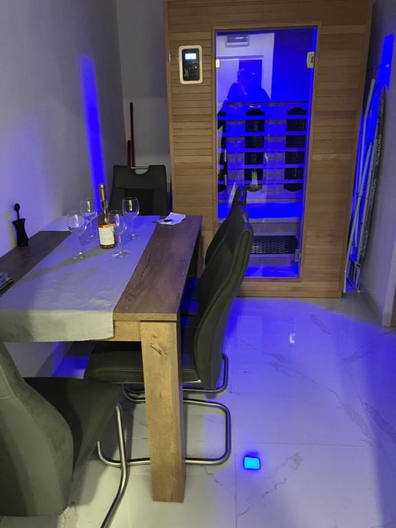 a wooden table with chairs and wine glasses on it at Borsalino Apartman in Veszprém