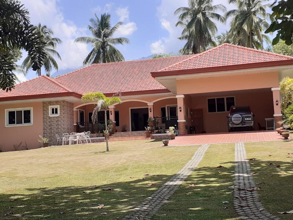 een huis met een gazon ervoor bij Villa Estela guesthouse in Bacong