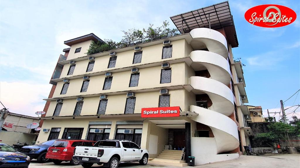 Spiral Suites Hotel في مانيلا: شاحنة بيضاء متوقفة أمام مبنى