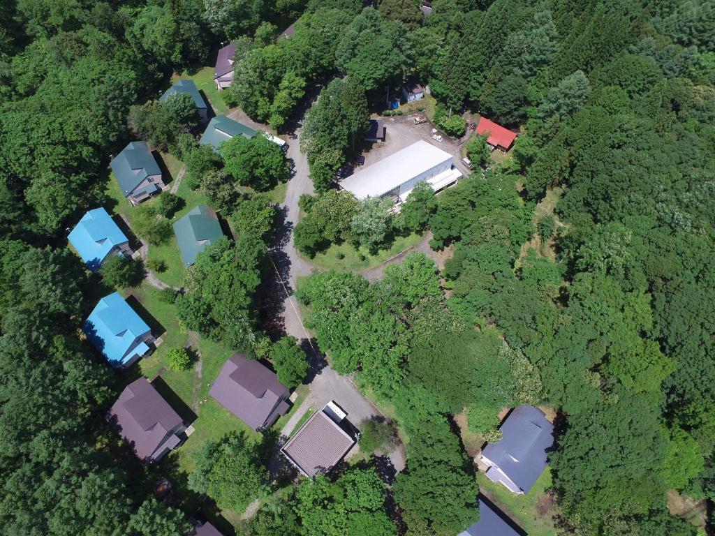 een uitzicht op een tuin met huizen en bomen bij Labo Land Kurohime in Shinano