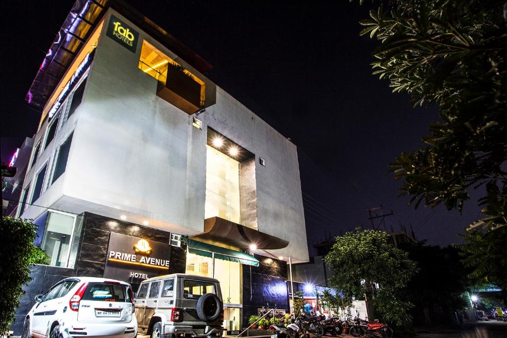 a building with cars parked in front of it at night at FabHotel Prime Avenue in Indore