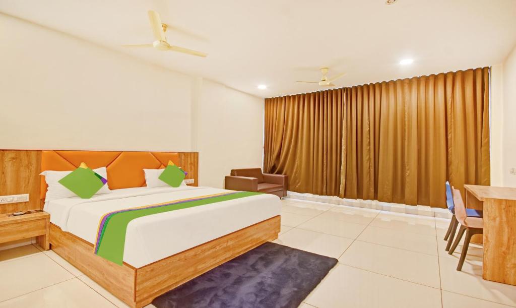 a bedroom with a bed and a table and chairs at Hotel Fun Regency in Ahmedabad