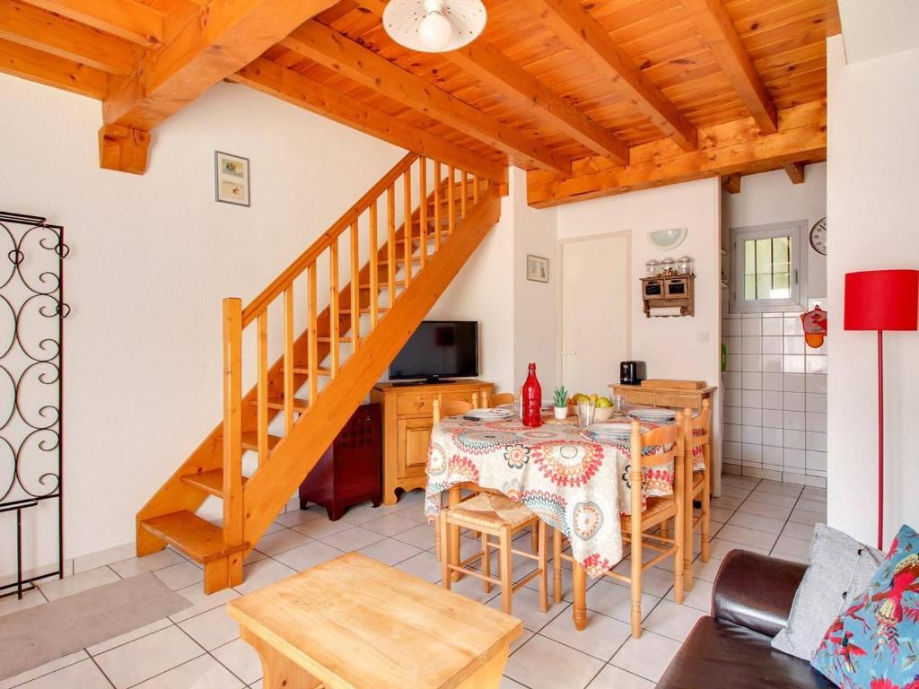 eine Küche und ein Esszimmer mit einem Tisch und einer Treppe in der Unterkunft Triplex Calme 6 Pers, Terrasse, Parking, Proche Station Ski - FR-1-402-90 in Esquièze - Sère