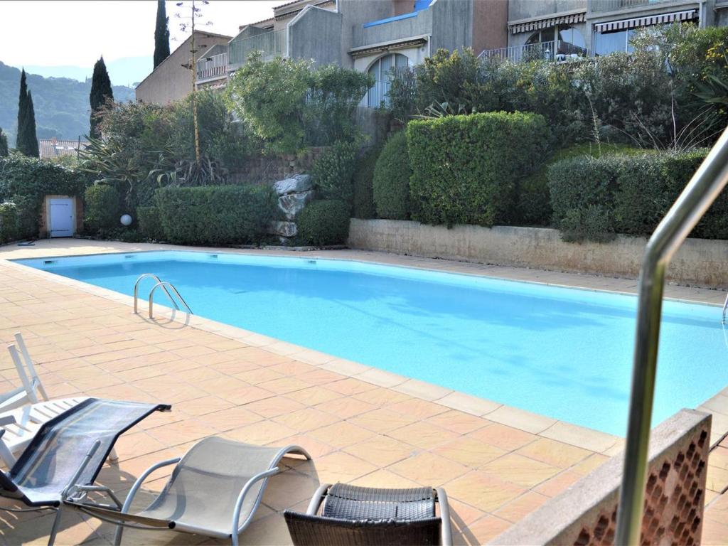 a large swimming pool with chairs next to a building at Appartement Cavalaire-sur-Mer, 3 pièces, 4 personnes - FR-1-226B-78 in Cavalaire-sur-Mer