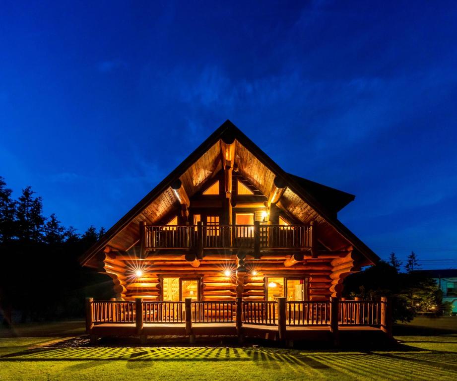 Cabaña de madera con terraza por la noche en Suite Villa Hakone Sengokuhara Canadian Log, en Hakone