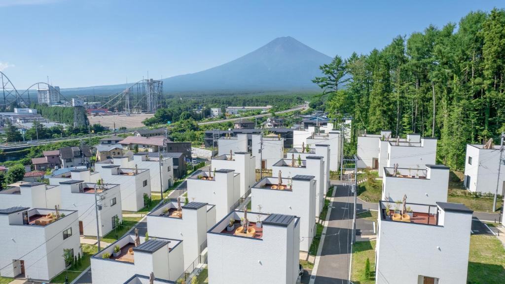 富士吉田市にある富士グランヴィラーTOKIーの山々を背景にした白いアパートメントの建物を空中から望む