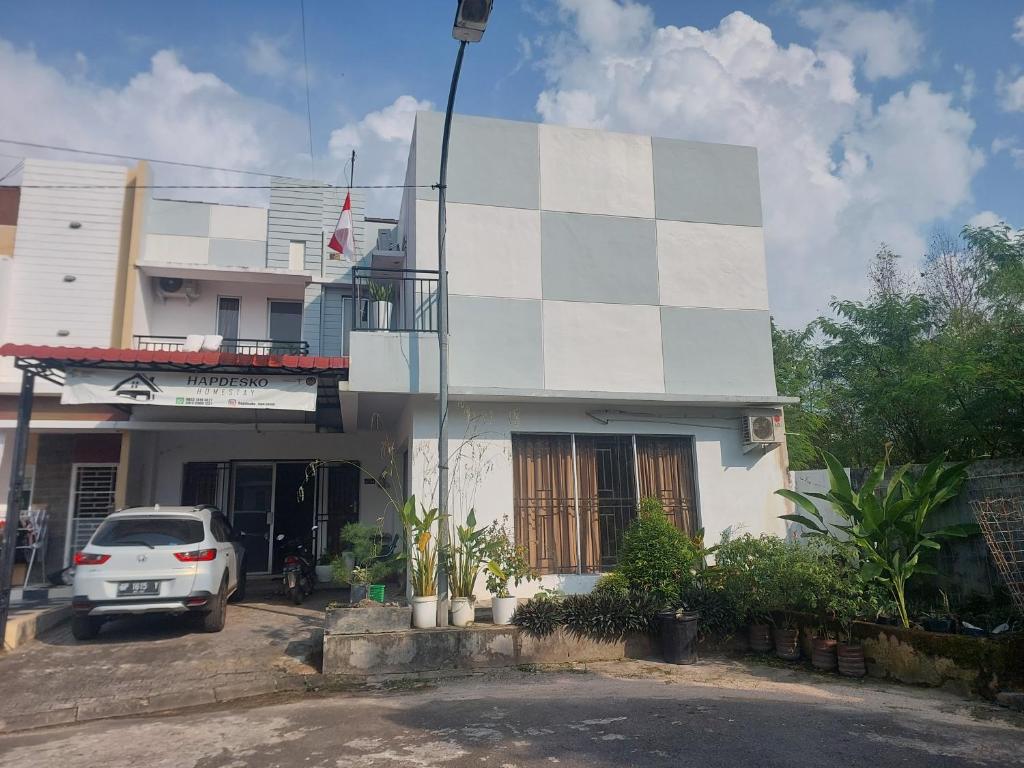 a white car parked in front of a building at HAPDESKO HOMESTAY in Batam Center