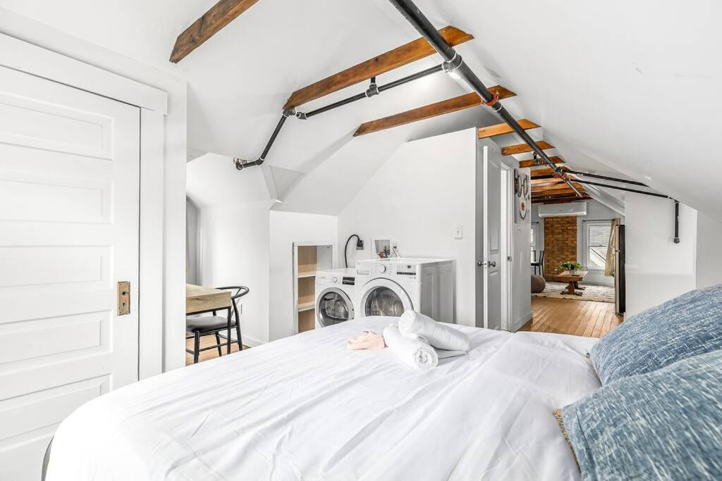 a bedroom with a white bed and a table at Stately Studio Apartment in Detroit