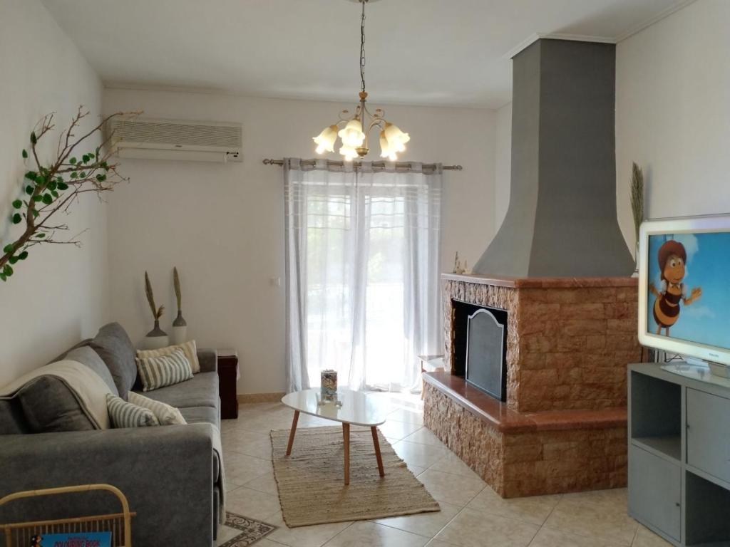 a living room with a couch and a fireplace at The mulberry apartment in Korfos