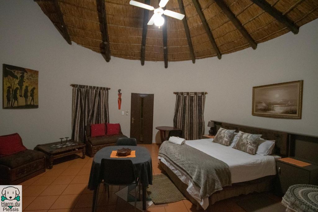a bedroom with a bed and a couch and a ceiling at Tipperary Game Lodge - Mbombela in Karino