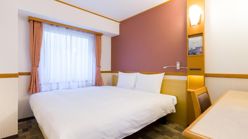 Postel nebo postele na pokoji v ubytování Toyoko Inn JR Yokohama sen Sagamihara Ekimae