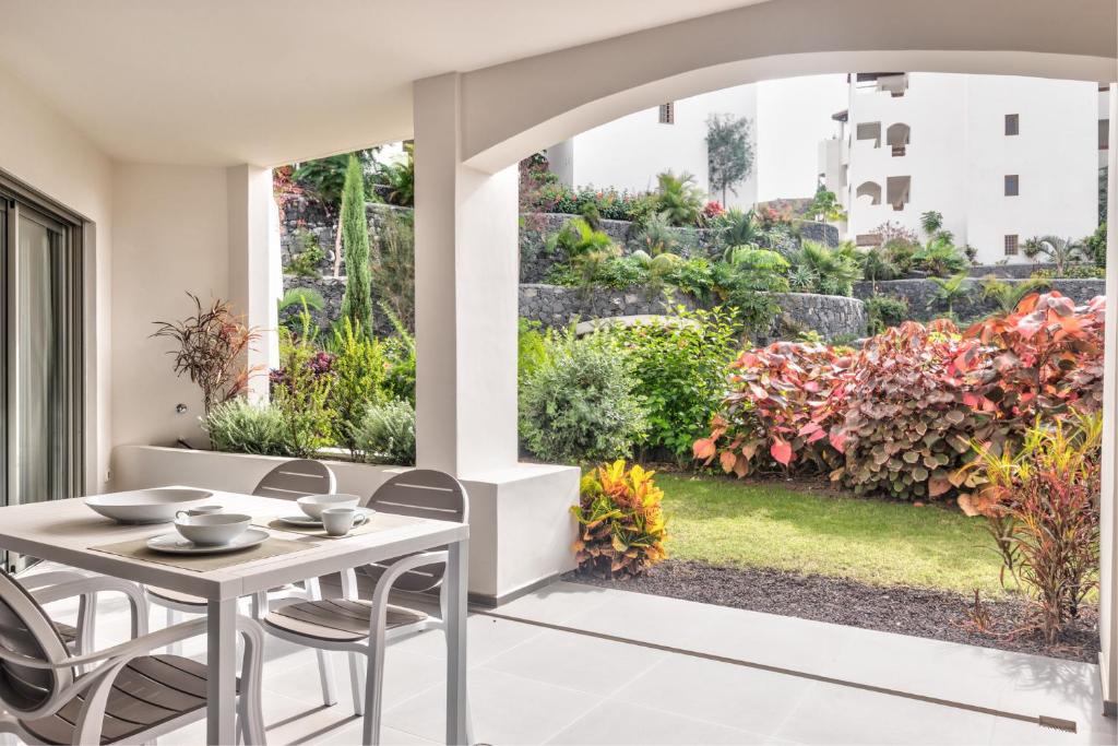 a patio with a table and chairs and a garden at Jardines - Tabor 0-2 POOL VIEW & GARDEN 1B in Palm-mar