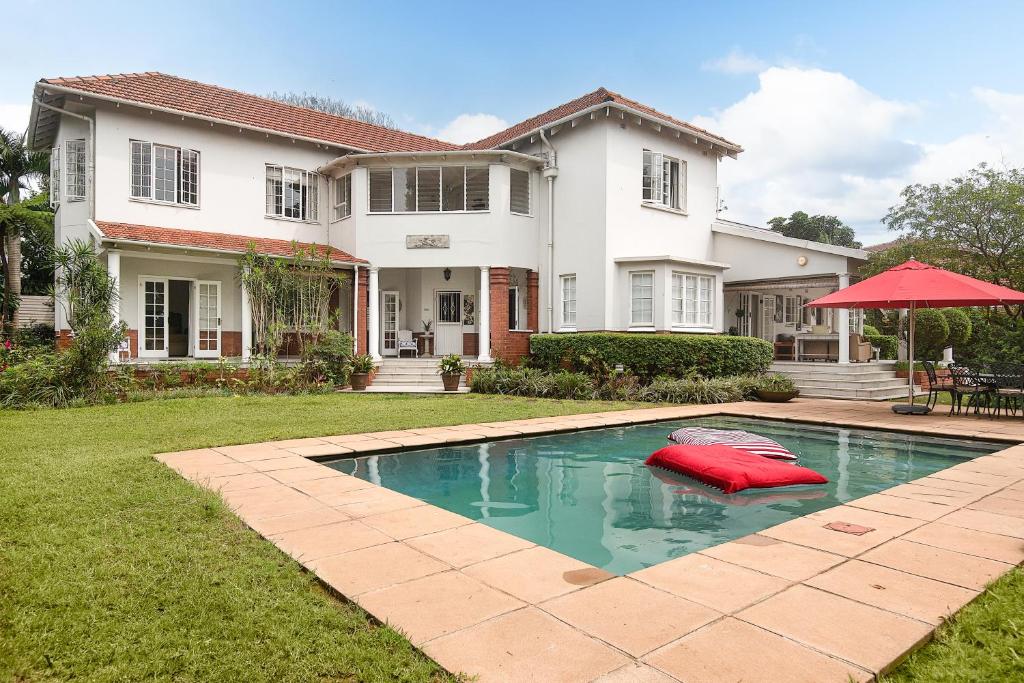 a house with a swimming pool in front of a house at Isoyi On The Mill in Durban