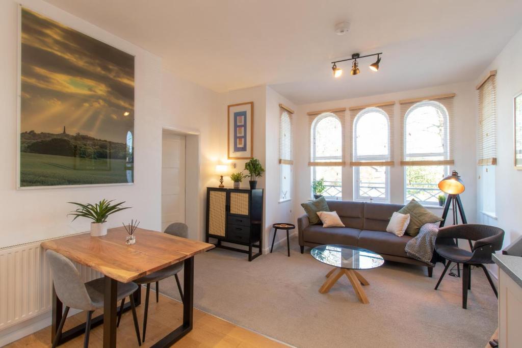 een woonkamer met een bank en een tafel bij Crescent House Apartments in Telford