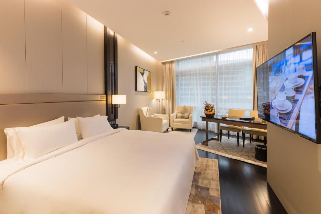 um quarto de hotel com uma cama grande e uma televisão em Banyan Signatures Pavilion Kuala Lumpur by Opus Hospitality em Kuala Lumpur
