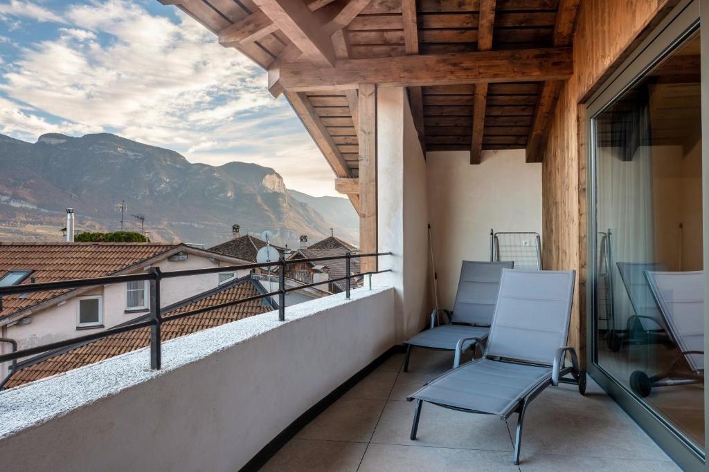 balcón con 2 sillas y vistas a las montañas en Eichhof Apartment Wacholder en Termeno