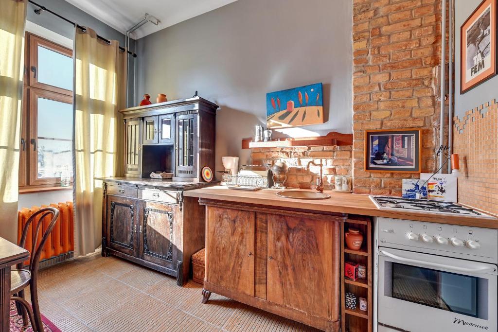 a kitchen with wooden cabinets and a stove top oven at Danzig 1925 Old Town Apartment in Gdańsk