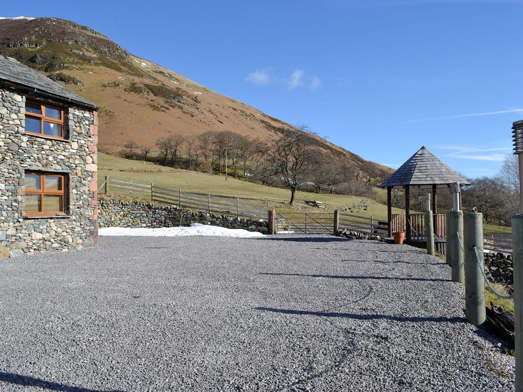 a stone building with a gazebo next to a hill at Lucys Lodge - Uk1260 in Threlkeld