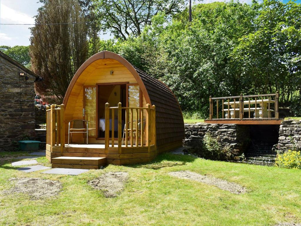 a small wooden iguana house in a yard at Riverside Mill Glamping Pod in Grayrigg