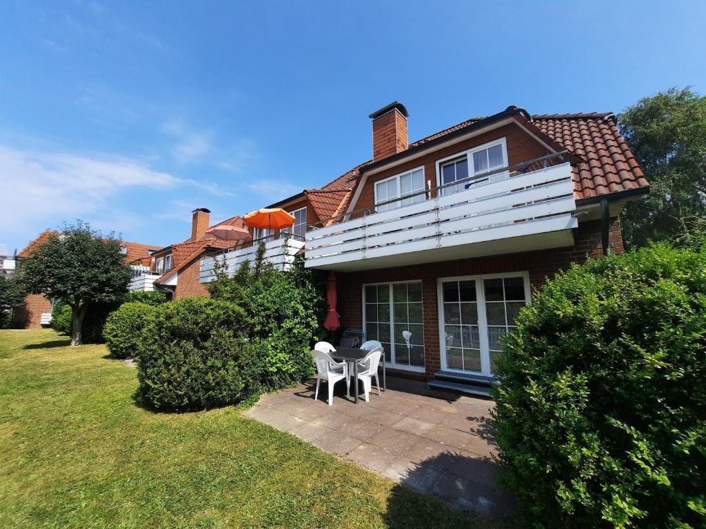 una casa con 2 sillas y una mesa en el patio en Residenz Vogelsand 1, en Cuxhaven