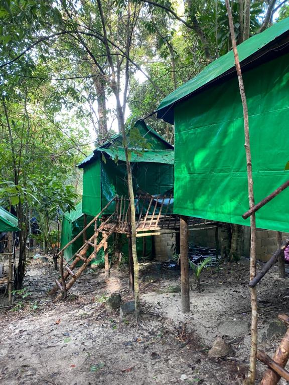 una cabaña verde en el bosque con árboles en Sweet Jungle Glamping, en Koh Rong